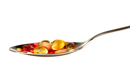 colorful pills on spoon on white background close-up