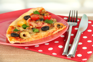 plate with a slice of delicious pizza on wooden background