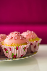 Leckere glasierte Mini-Kuchen verziert mit Zuckerherzen