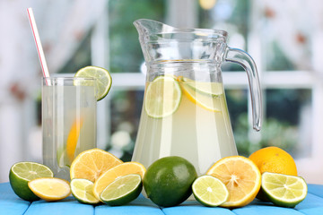 Citrus lemonade in pitcher and glass of citrus around