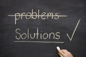 Fototapeta premium problems and solutions written on a blackboard showing a hand ho