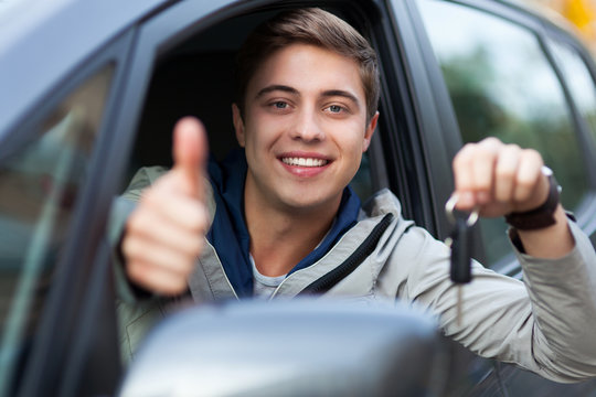 Young Man Sitting In Car Holding Car Keys