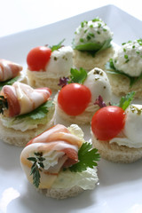 Plate of mixed appetizers with ham and tomato