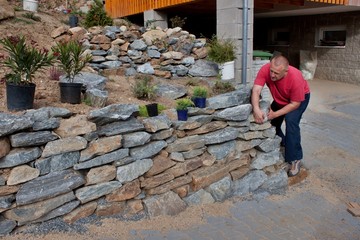 man builds a stone wall