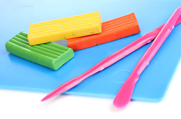 Children bright plasticine on desk with stacks isolated on