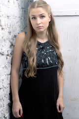 Fototapeta premium girl dress stands against brick wall