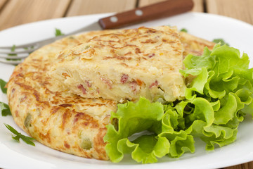 spanish omelet with lettuce on the white plate