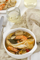 fish with seafood and vegetables in white bowl