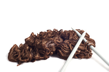 Sewing needles with brown scarf isolated on white