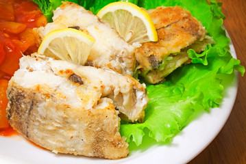 Fried haddock fish with vegetables and greens