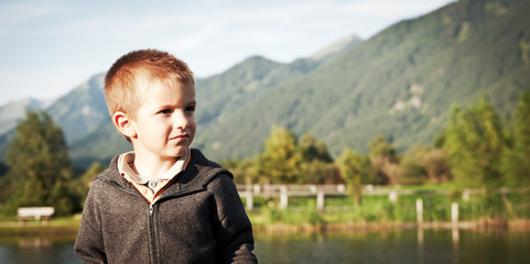 Portrait of four year old boy outdoors in the mountains. 