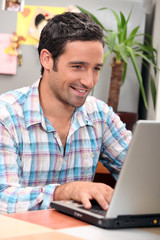 Man laughing in front of computer