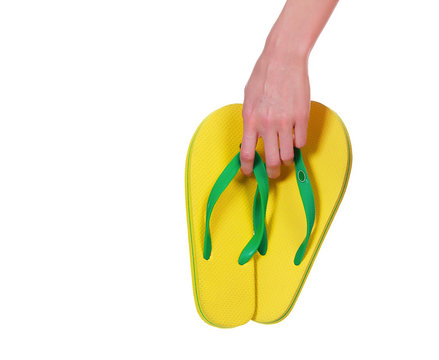 Female hand with yellow flip-flops on white