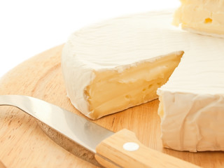 Circle Brie  cheese on wooden desk with knife isolated