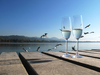 Two champaign glasses against a lake