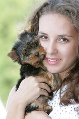 young happy woman with yorkshire terrier puppy outdoors