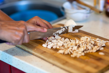 Woman's hands chopping mushrooms