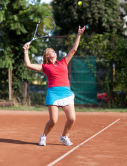 Young woman tennis player serving the ball