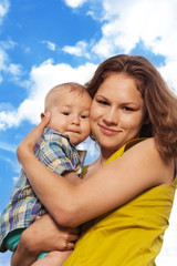 Fototapeta na wymiar happy mom and son on cloudy background