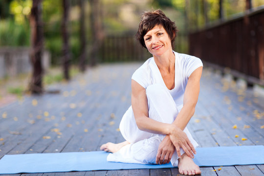 fit middle aged woman relaxing after workout