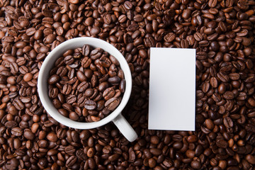 Kaffeetasse in Bohnenhaufen mit Notiz