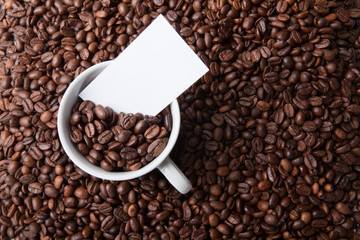 Kaffeetasse in Bohnenhaufen mit Notiz