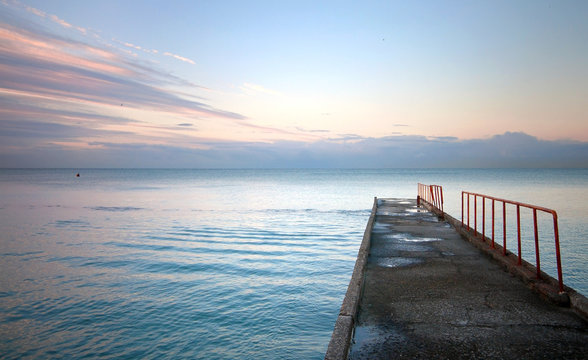Fototapeta Old stone pier with red railing. Black Sea coast. Russia, Sochi