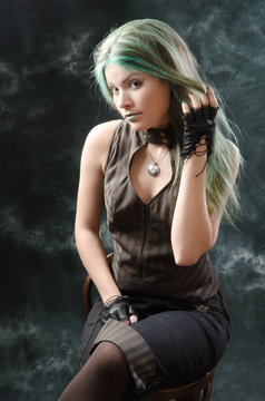 Steampunk-styled girl posing at studio