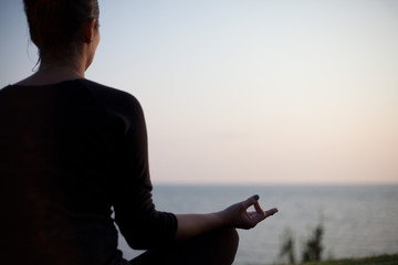 young woman meditating by the sea