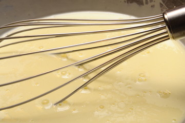 Manual whisk mixing cream and egg