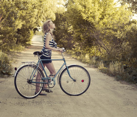 beautiful girl with a bicycle on the road