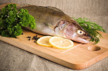 Pike perch on a wooden kitchen board, it is isolated on white