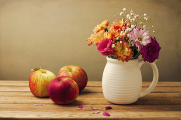 Beautiful flower bouquet and fresh apples on wooden tabletop