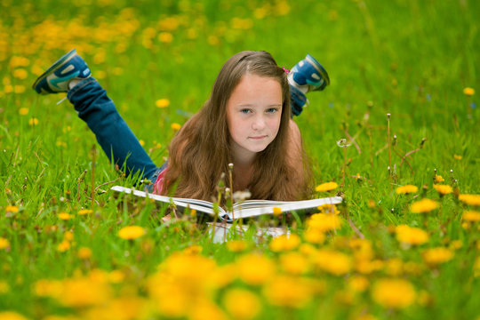 A Girl 11 Years Old Reads A Book In The Meadow