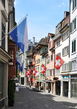 Old street in Zurich decorated with flags for the Swiss National