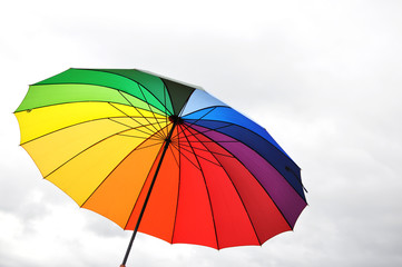 Rainbow umbrella against cloudy sky