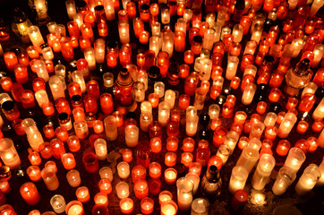 Many burning candles in graveyard at night