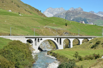 Fototapeta na wymiar Bridge over mountain river. Furka pass, Switzerland