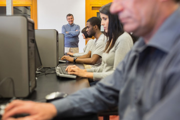 Teacher standing at front of computer class