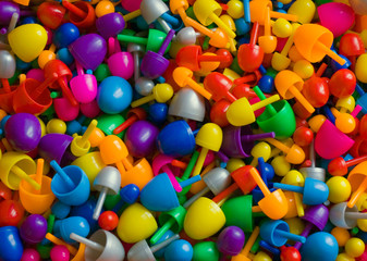 Background with multicolored random sized plastic mosaic pins