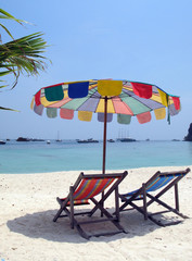 Sun chair under umbrella on a tropical sandy beach of Phi-Phi is