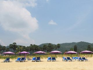 Fototapeta na wymiar Row of umbrellas and sunbeds at a tropical beach