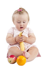 small child with an orange and a banana