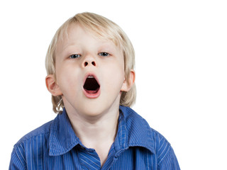 Tired cute young boy yawning.