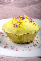 Cupcake mit Zitronen Buttercreme und bunten Zuckerperlen