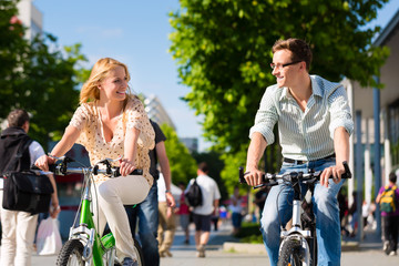 Paar in Stadt fährt mit Fahrrad in Freizeit