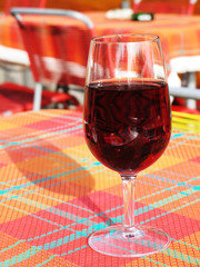 Glass of red wine on checked tablecloth
