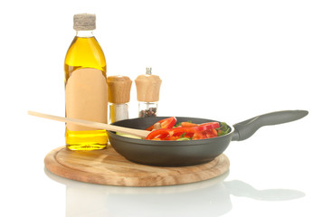 frying pan with vegetables on white