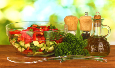 Obraz na płótnie Canvas Fresh salad and oil on green background