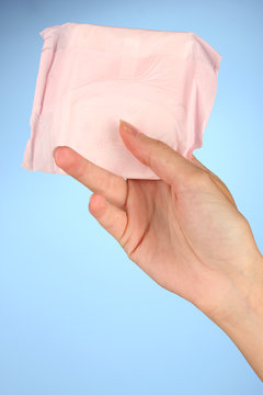 woman's hand holding a panty liner in individual packing